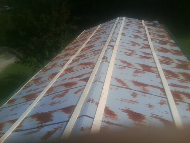 Rusted metal roof panels with new wood purlins before replacement — Storm Damage Roof Repair in Wardensville by Roofing Brothers
