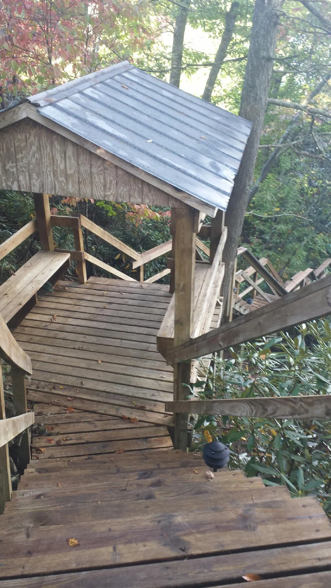 Metal roofed shelter over wooden steps on a wooded walkway — Skylight Repair & Installation work by our crew in Wardensville