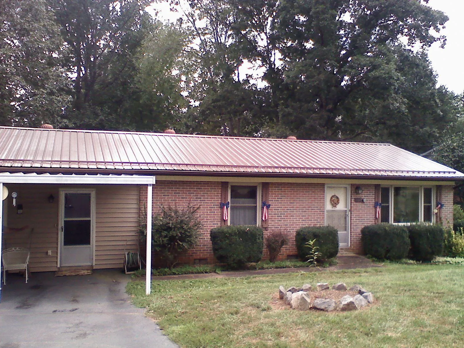 Bronze metal roof and carport on a brick ranch home — Roof Repair work by our crew in Wardensville